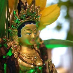 Close-up on the face of a bronze Tara statue.