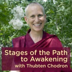 Venerable Chodron smiling with two white flowers beside her head.