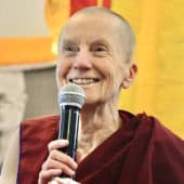 Venerable Sangye Khadro smiles while speaking into a microphone.