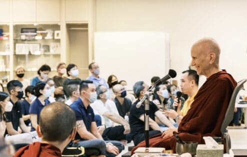 Venerable Chodron smiling while teaching to a large crowd.