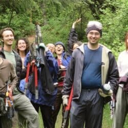 A group of young people working in the Sravasti Abbey forest smiling at the camera.