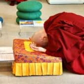 A Buddhist nun bowing on a bowing cushion.